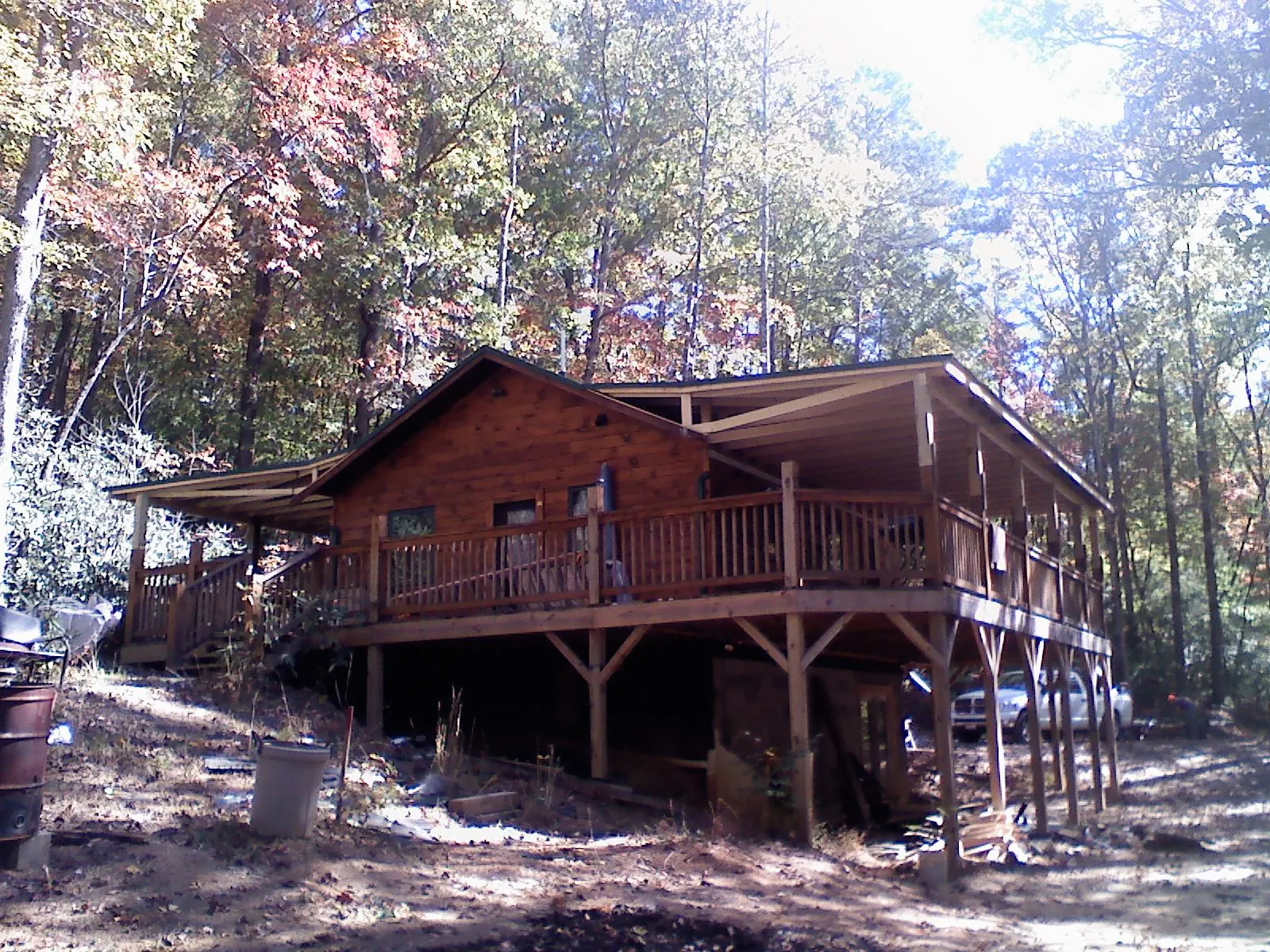Log cabin with a wraparound porch and metal roof in the fall in Easley