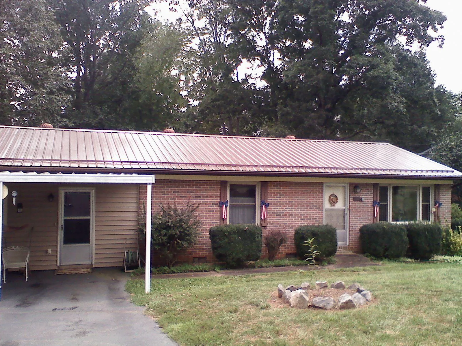 Bronze metal roof and carport on a brick ranch home — Roof Repair work by our crew in Easley